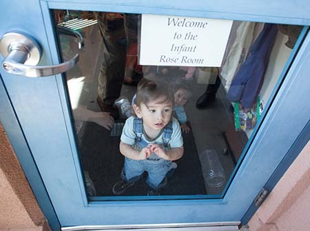 Toddler Child looking out of glass door
